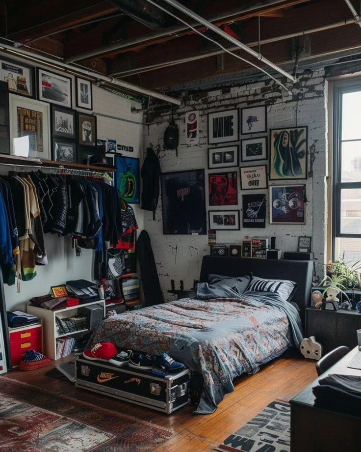 Industrial bedroom with exposed brick walls, framed art, a bed, and clothing racks in a loft setting.
