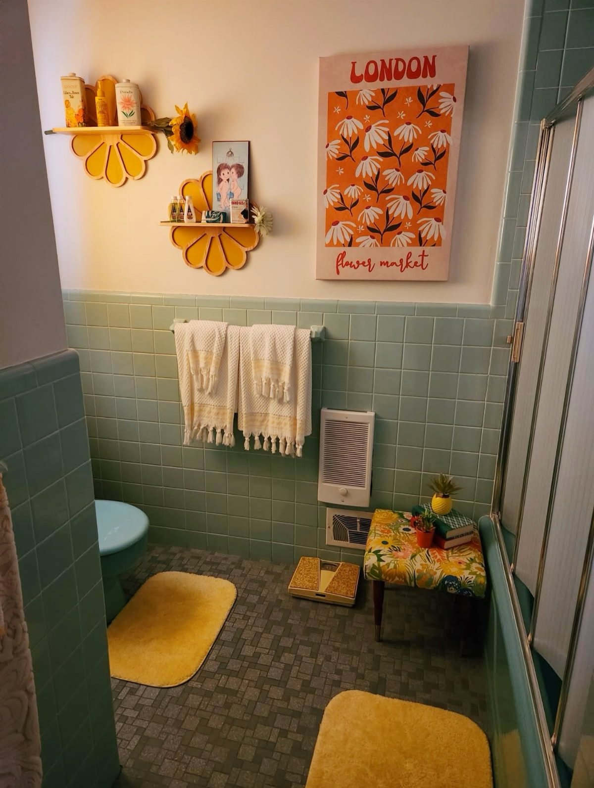 Retro bathroom with teal tiles, yellow flower shelves, and floral decor elements.