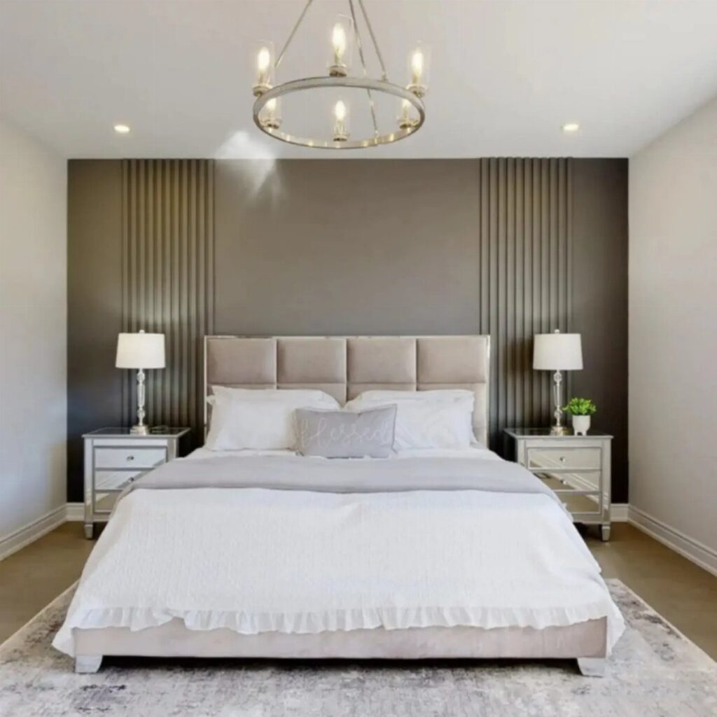 A modern bedroom with a dark grey accent wall featuring vertical wood slat panels and a large bed.